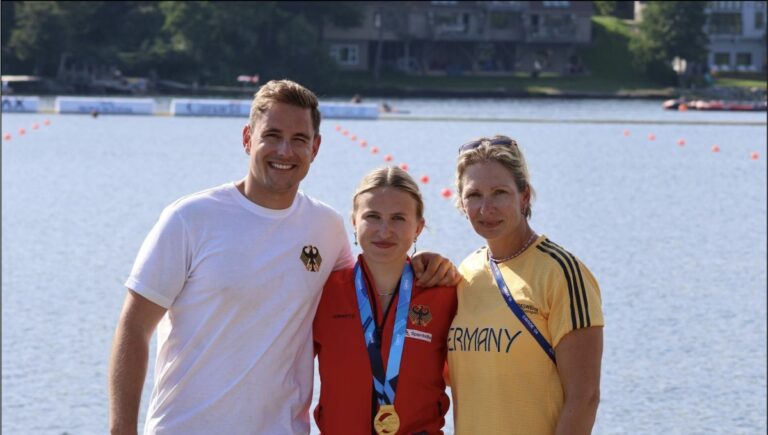 Carlotta Loske mit ihren Trainern Dominik Ziegler und Katrin Wagner-Augustin nach ihrem Gold im C1 500 m bei der Weltmeisterschaft 2026