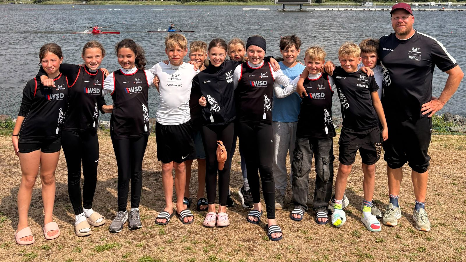 Die Nachwuchsgruppe des KC Potsdam 2026 mit Trainer Kurt Kuschela an der Regattastrecke