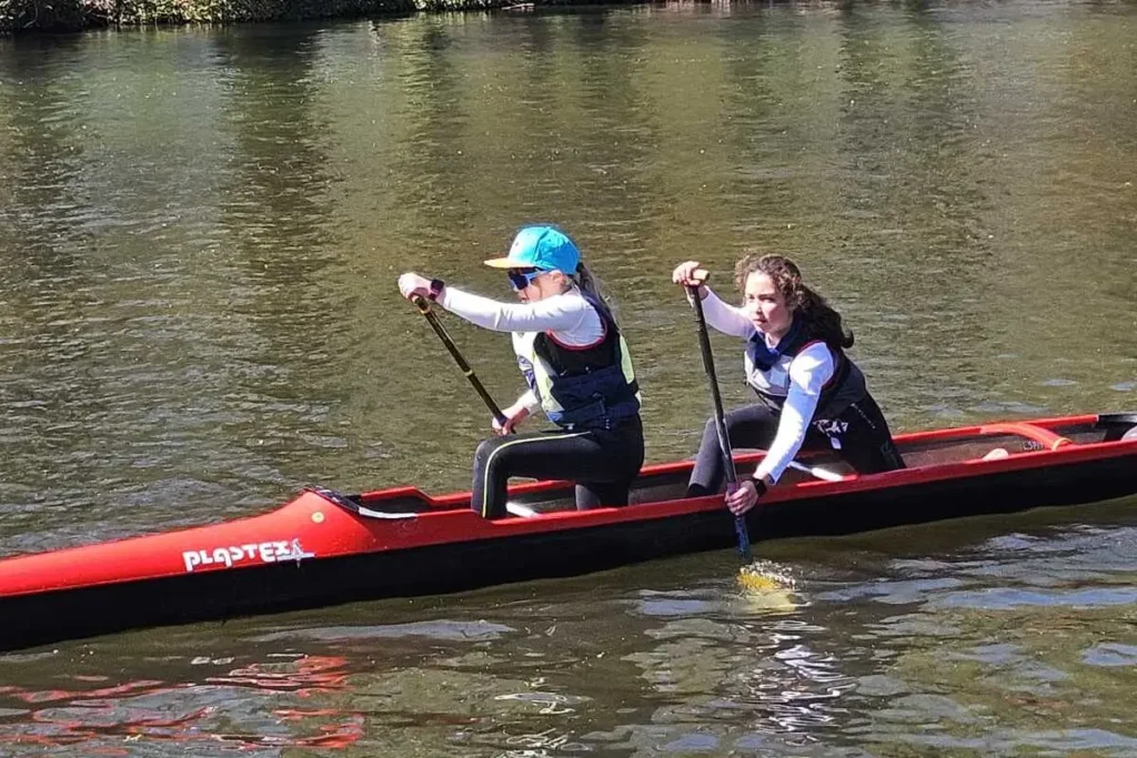 Zwei Kinder im Zweier-Kajak auf dem Wasser