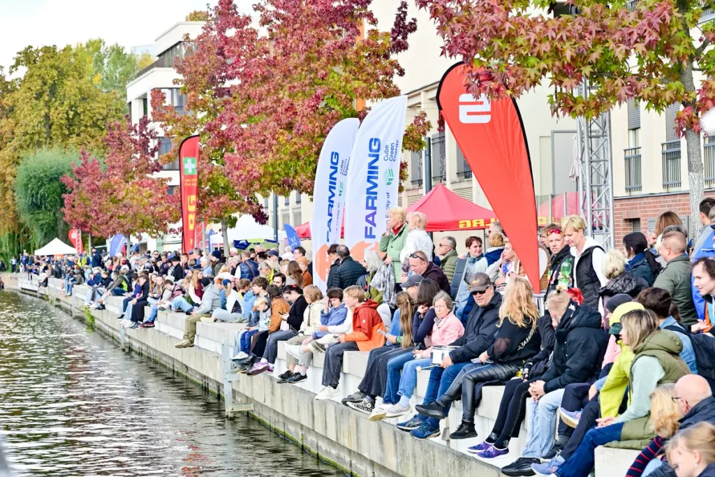 Zuschauerinnen und Zuschauer sitzen an der Alten Fahrt und verfolgen den Potsdamer Kanusprint