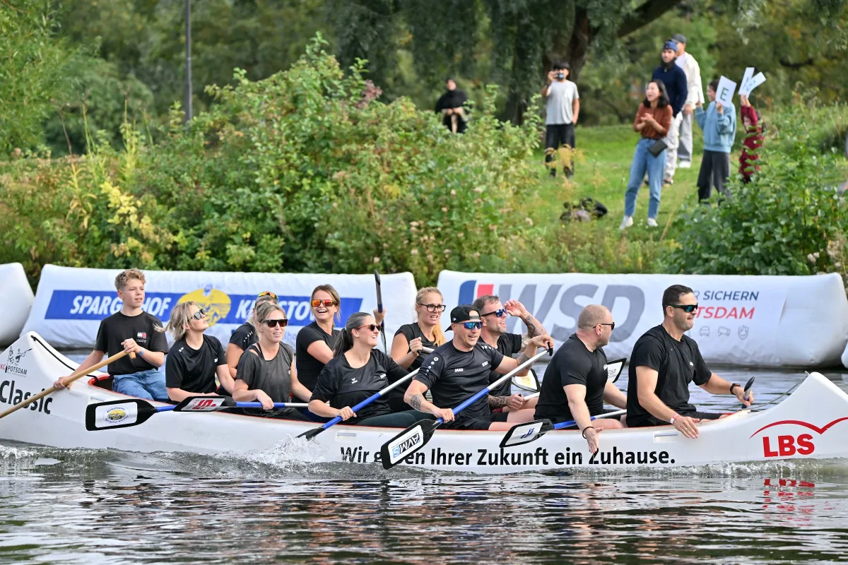 Drachenboot mit Besatzung vor den Banden von WSD und LBS