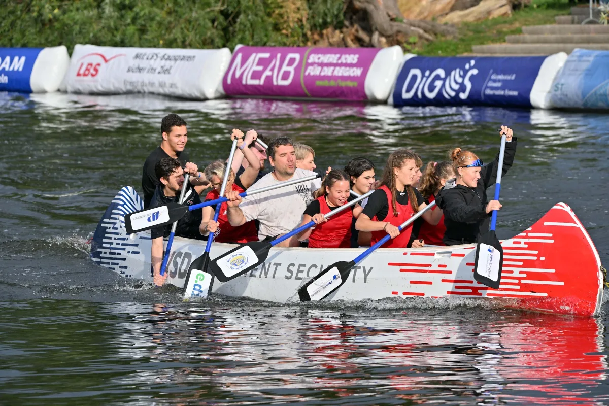 Zuschauerrennen: Team im roten Boot mit Paddeln vor MEAB-Banden