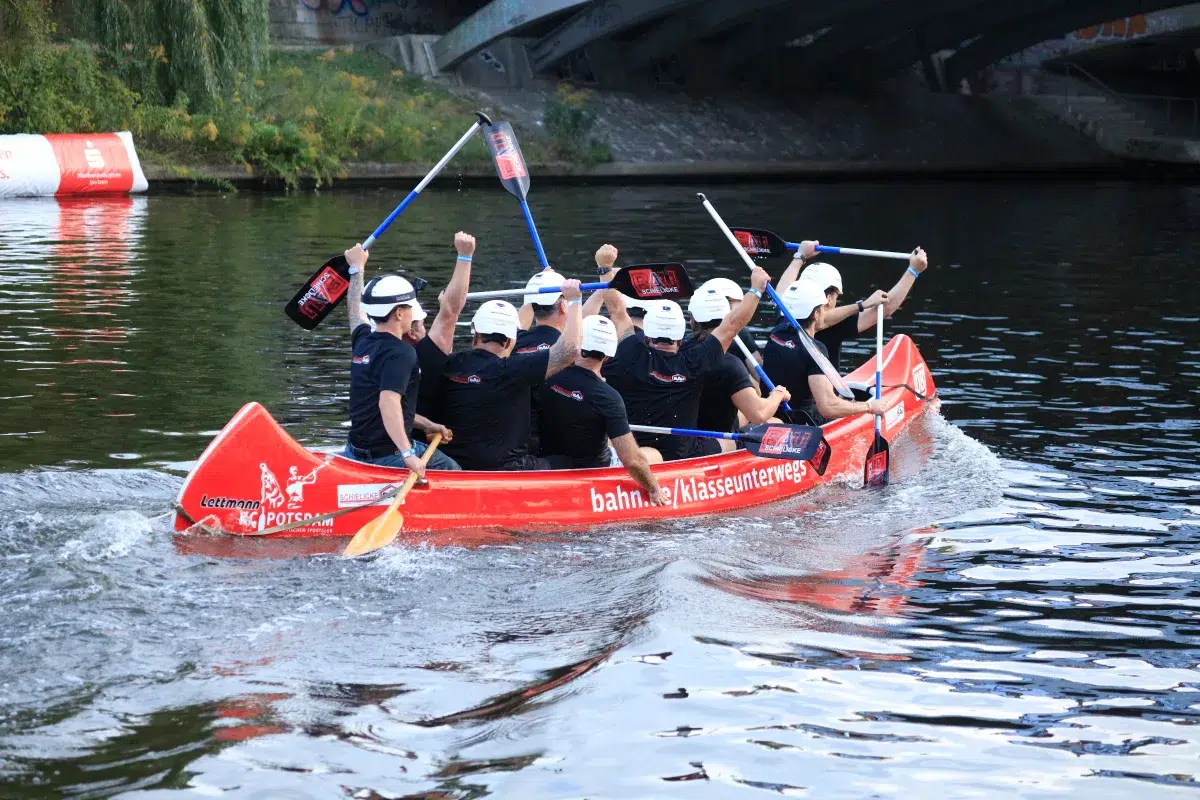 Drachenboot mit Besatzung in weißen Helmen im Rennen